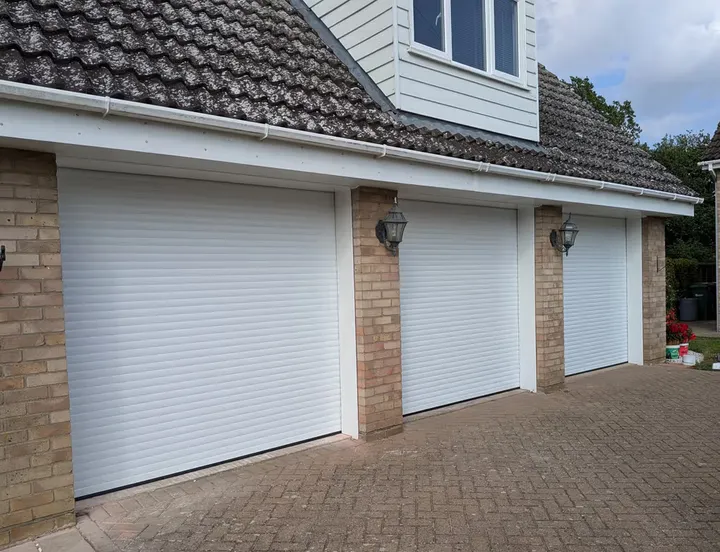 White 55mm roller garage door fitted to a triple garage