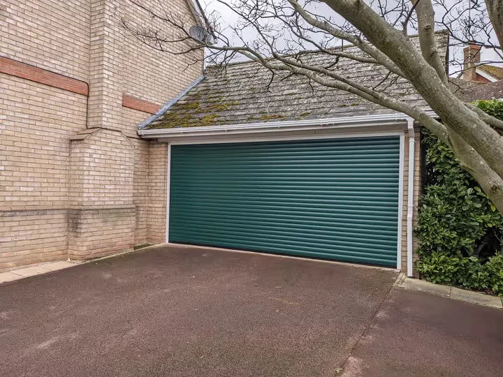 Moss green 77mm roller garage door fitted to a double garage