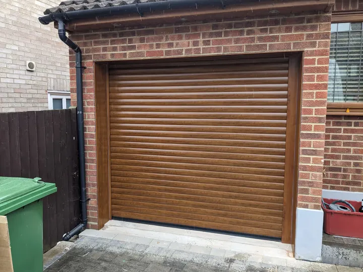 Golden oak woodgrain 77mm roller garage door fitted to a single garage