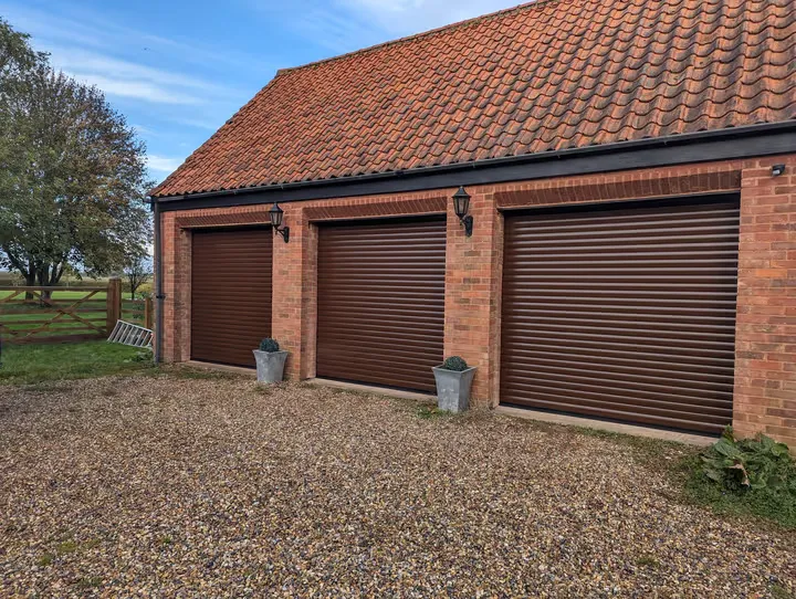 Dark brown 77mm roller garage door fitted to a triple garage