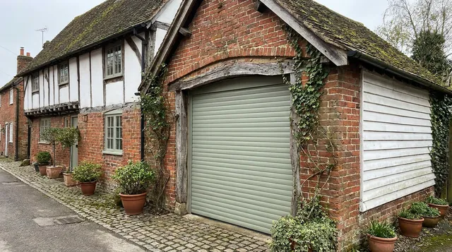 Cottage garage in Halstead with a made to measure roller door in a soft heritage colour