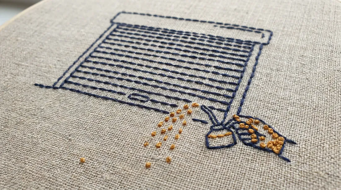 Embroidered linen artwork of a roller garage door being tended with a stitched oil can