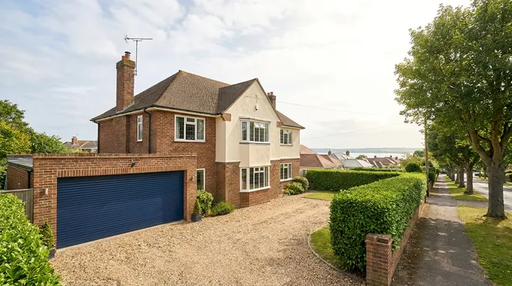 Detached home on a tree lined Southend avenue with a navy double roller garage door
