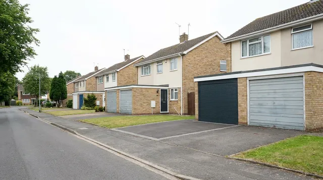 Row of post war semis in Witham with one garage upgraded to an anthracite roller door